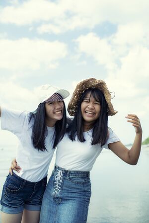 two cheerful asian teenager happiness emotion on sea beachの写真素材
