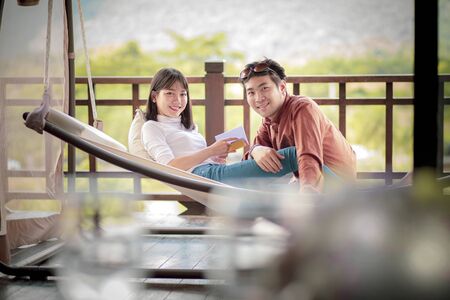 younger asian man and woman relaxing in home terraceの写真素材