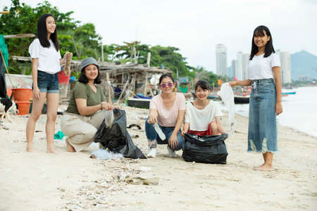 group of asian volunteer make a cleaning sea beach out of a plastic litterの写真素材
