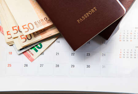 red cover passport book and 50 euro banknote on calendar dateの写真素材