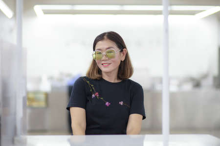 portrait asian woman toothy smiling face in white cafeの写真素材