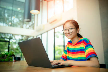 asian teenager working on computer laptop with smiling faceの写真素材
