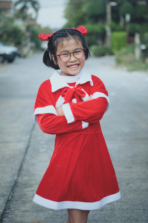 asian girl wearing red suit of santa claus toothy smiling with happiness faceの写真素材