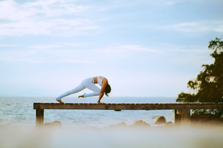 woman doing yoga at island beach pierの写真素材