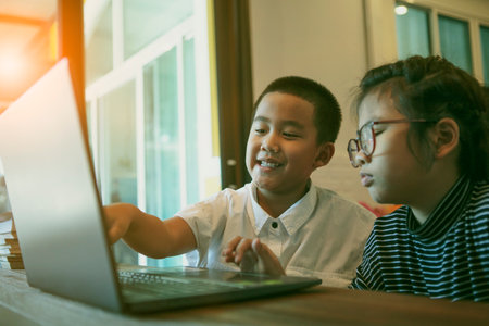 asian children learning on line with computer laptop at home living room