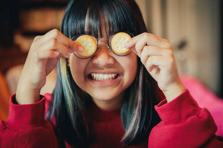 asian teenager making cream cracker close eye glassesの写真素材
