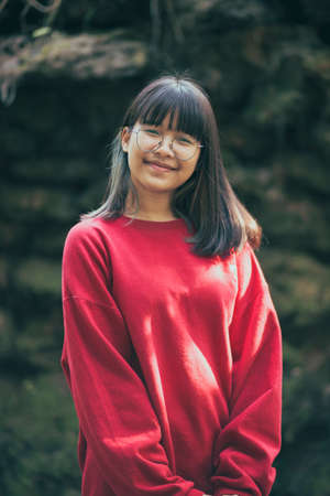 portrait of asian teenager wearing eyeglasses standing outdoor