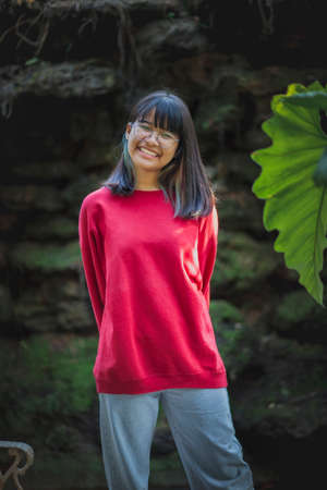portrait of asian teenager wearing eyeglasses standing outdoorの写真素材