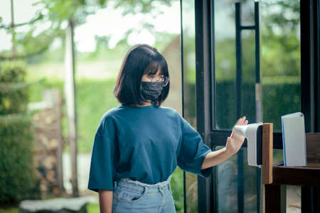 asian teenager temperature hand test at cafe doorの写真素材