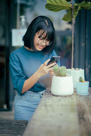 asian teenager taking photo of cactus potの写真素材