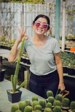 happiness woman standing in cactus green houseの写真素材