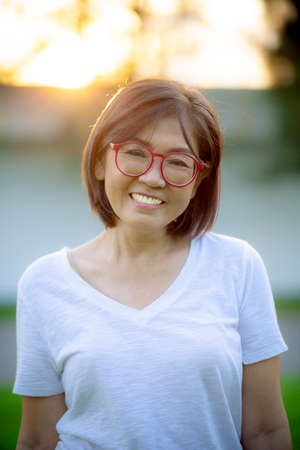 toothy smiling face of good healthy woman standing outdoor with casual clothesの写真素材