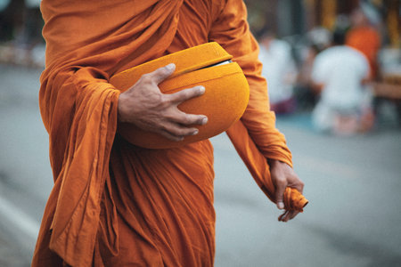 thai buddha monk holding buddhist bowl for receiving morning food offeringの写真素材