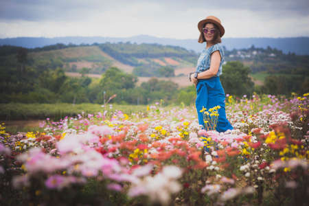 woman standing in blooming flower garden with relaxing mood