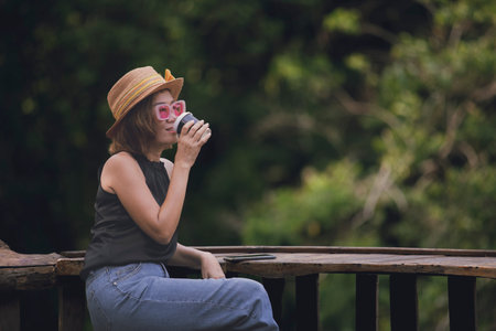 beautiful asian woman drinking hot coffee in take a way cupの写真素材