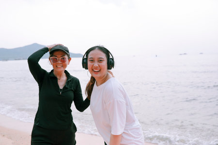 couples of asian woman wearing sport casual suit happiness on sea beachの写真素材