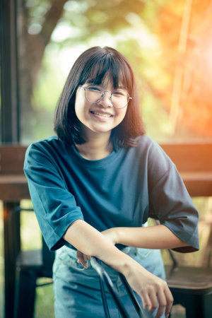 asian teenager toothy smiling with happiness face standing in home living roomの写真素材