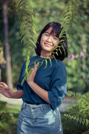 asian teenager relaxing in fern botanical gardenの写真素材