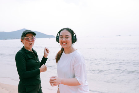 two asian woman wearing sport casual wearing happiness on sea beachの写真素材