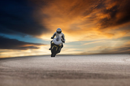 man riding sport motorcycle on concrete track against beautiful dramatic skyman riding sport...