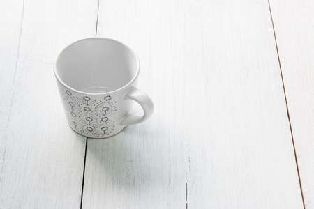 Green pattern cup on white wooden backgroundの写真素材