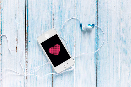 smartphone with earphone and heart symbol on screen (phone, smartphone, mobile)の写真素材