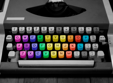 black and white typewriter on wooden background | rainbow keys typewriter | middle age typewriter | front of typewriter | closeup typewriterの写真素材
