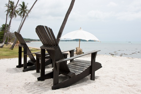twin black chair on white sand beachの写真素材