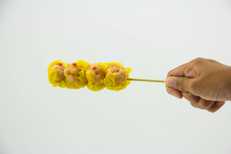 Chinese shrimp streamed dumpling stick in hand on white backgroundの写真素材