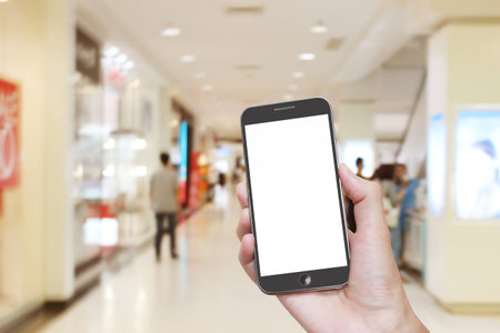 Man hand holding smart phone with isolated white screen,blurred background styleの写真素材