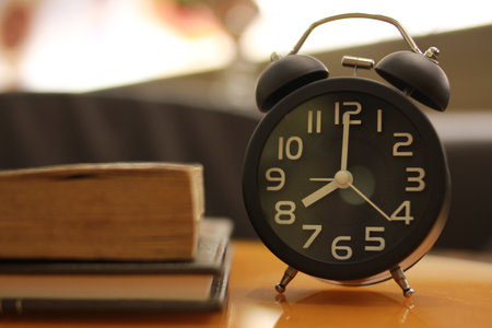 Alarm clock and books on the table. Back to school concept.の写真素材