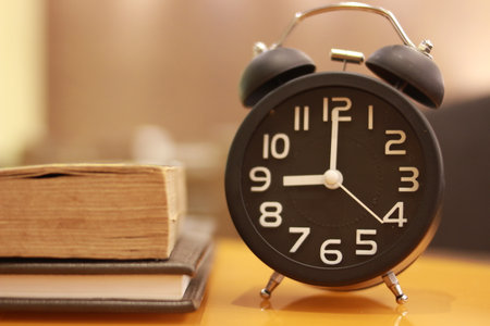 Alarm clock and books on the table. Back to school concept.の写真素材