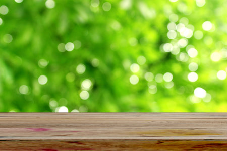 Empty wooden table over blur green bokeh background, product display montageの写真素材