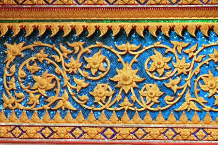 A decorative wall with flower carvings in a templeの写真素材
