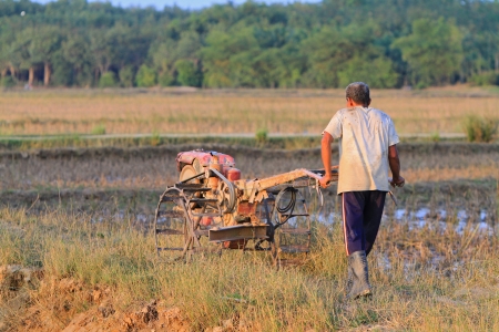 Nakhon Si Thammarat, Thailand - FEBRUARY 18, 2011 : Unidentified farmer plows the paddy field using tiller tractor to prepare the soil before the rainy season.のeditorial素材