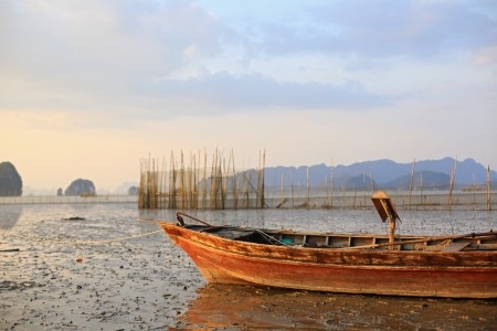 Fishing boat stranded on mud at low tide, Ao Thalane, Krabi province, Thailand の写真素材