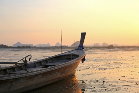 Fishing boat stranded on mud at low tide, Ao Thalane, Krabi province, Thailand の写真素材
