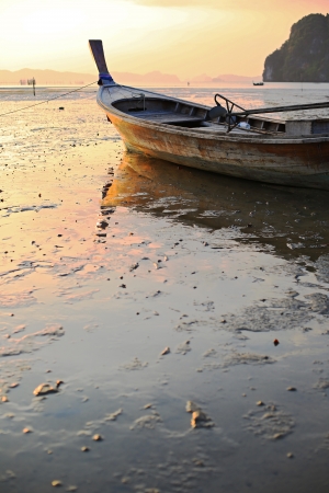 Fishing boat stranded on mud at low tide, Ao Thalane, Krabi province, Thailand の写真素材
