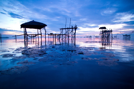 Silhouette traditional fishing method using a bamboo square dip net with sunrise background in Patthalung, Thailandの写真素材