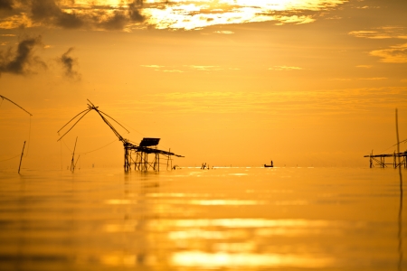 A fisherman standing on his boat and bamboo machinery  square dip net , Pattalung, Thailandのeditorial素材