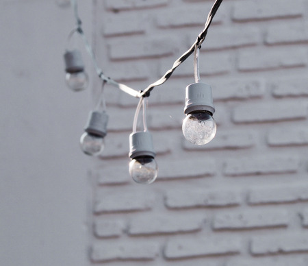 Small hanging lamp in front wall white brickの写真素材