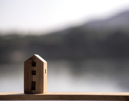 One Wood toy house with blur forest and lake backgroundの写真素材