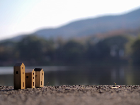 Three Wood toy house with blur forest and lake backgroundの写真素材