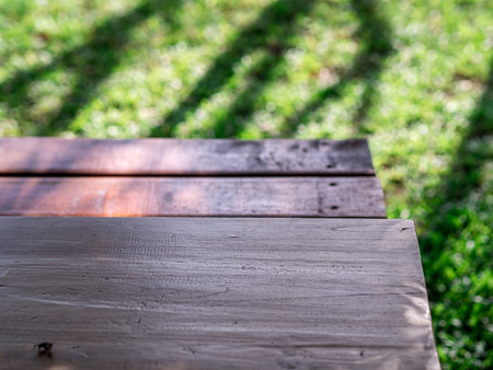 Wood chair in green garden on wood floor under shadow of tree