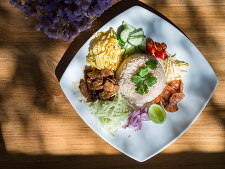 Rice Mixed with Shrimp paste in white plate on wood tableの写真素材