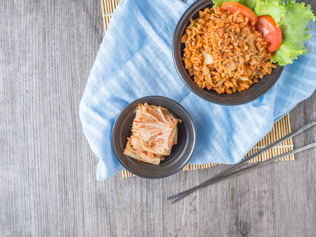 Kimchi fries rice in black and white plate on wood backgroundの写真素材