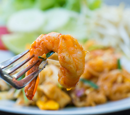 Pad thai with prawn serve in white plate with vegetable and lemonの写真素材