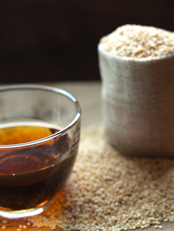 Sesame oil in one gleass on wood table, prepare for cooking concept.の写真素材