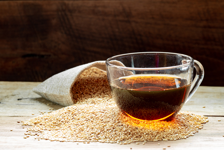 Sesame oil in one gleass on wood table, prepare for cooking concept.の写真素材