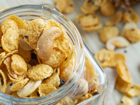 Cornflakes caramel in glass bottle on wood background.